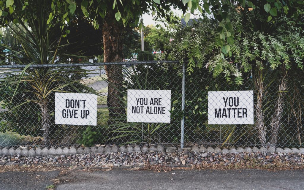 Metal Garden Fence With Signs Which Have Positive Messages On Them