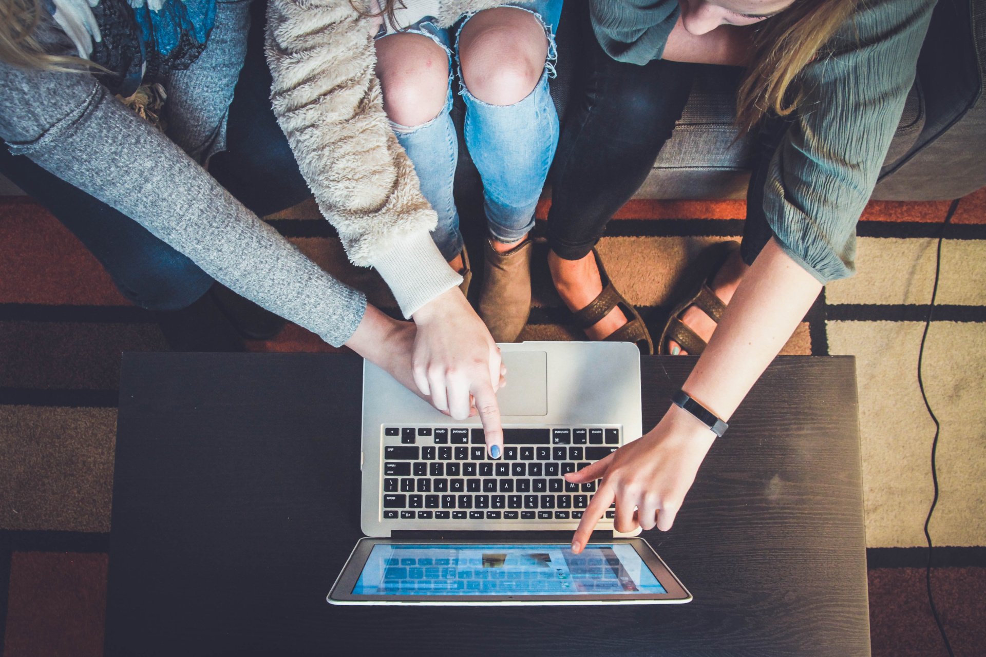 Three Ladies Huddled Around A Laptop